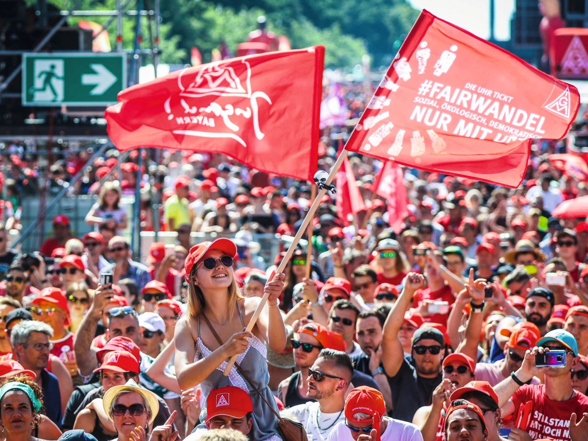 junge Metallerin weht Fahne auf FairWandel-Kundgebung in Berlin 2019